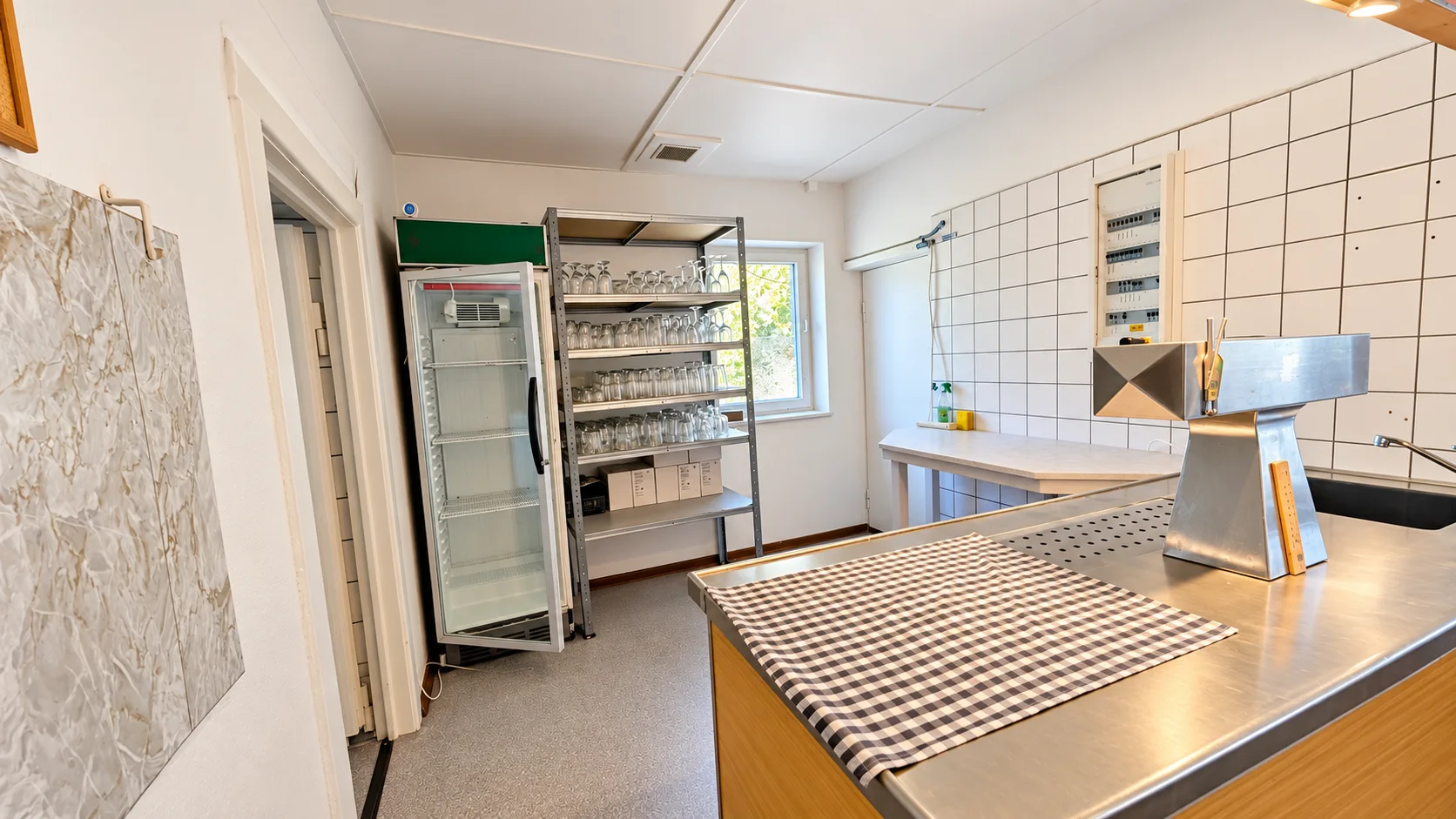 Küche des Vereinsheims mit Geschirr, Gläsern und Getränkekühlschrank